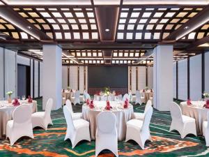 a conference room with white tables and chairs and a projection screen at Mercure Jakarta Sabang in Jakarta +94 photos