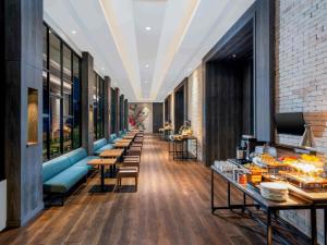 a corridor of a restaurant with tables and chairs at Mercure Jakarta Sabang in Jakarta