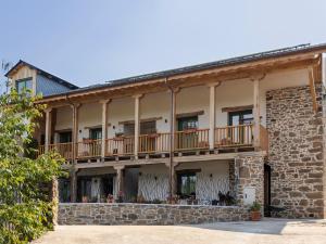 an old stone building with balconies and windows at La Casa de las Flores in Noceda del Bierzo