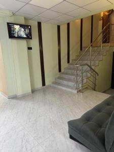 a lobby with a staircase and a tv on the wall at Inju in Temirtaū