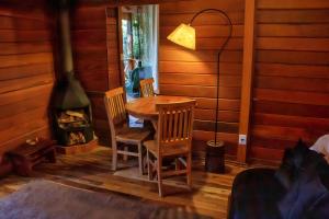 a dining room with a table and chairs and a fireplace at Chalé Monte Rei in Monte Verde