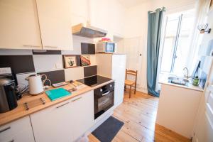 a kitchen with white cabinets and a counter top at Le Gîte d'Olympe in Cordes-sur-Ciel