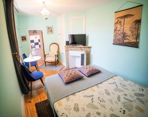 a bedroom with a bed and a table and chairs at Le Gîte d'Olympe in Cordes-sur-Ciel