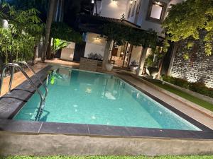a swimming pool in front of a house at Villa Dominikku in Negombo