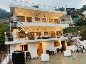 a large white building with stairs and chairs at The lake house in Bhīm Tāl