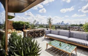 a patio with a couch and tables on a roof at The Standard London in London