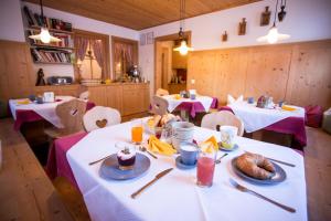 a dining room with two tables with food on them at Thomashof in Pfelders