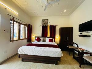 a bedroom with a bed and a flat screen tv at The lake house in Bhīm Tāl