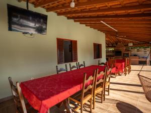 a dining room with a red table and chairs at Chácara Pimenta Vermelha in Socorro