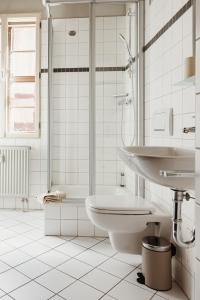 a white bathroom with a sink and a toilet at Boutique Apartment QLB est 1688 in Quedlinburg +29 photos