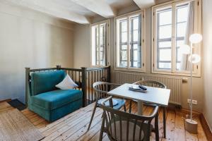 a living room with a table and a chair at Boutique Apartment QLB est 1688 in Quedlinburg
