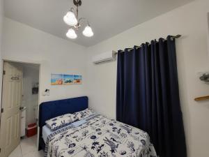 a bedroom with a bed and a blue curtain at Paseo Miami in Miami