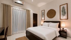 a bedroom with a large white bed and a window at The Ocean Breeze Villa in Tangalle