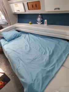 a bed in a room with a blue sheet on it at Bateau 66 in Le Barcarès