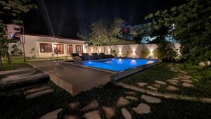 a swimming pool in the yard of a house at night at The Ocean Breeze Villa in Tangalle