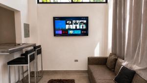 a living room with a couch and a tv on the wall at Loft privado con alberca - Cama King in El Centenario
