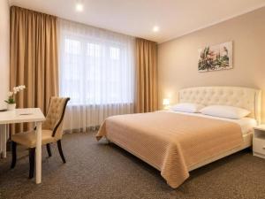 a bedroom with a bed and a desk and a window at Nika Apart hotel in Riga