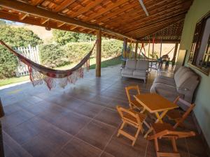 a porch with a hammock and a table and chairs at Chácara Pimenta Vermelha in Socorro