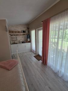 a bedroom with a bed and a large window at Holiday Home Kolka in Kolka
