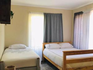 a bedroom with two beds and a window at Glenmore Sea View Appartments in Leisure Crest
