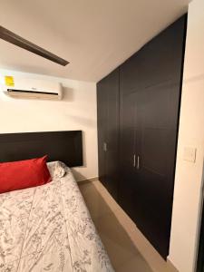 a bedroom with a bed and a black cabinet at Departamento Conjunto Mirador in Santa Cruz Huatulco +5 photos