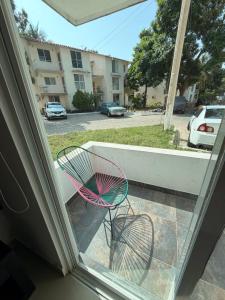 a chair sitting on a porch looking out of a window at Departamento Conjunto Mirador in Santa Cruz Huatulco