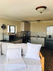 a living room with a white couch and a kitchen at Glenmore Sea View Appartments in Leisure Crest