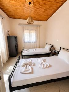 a room with two beds and a window at Ambelos, Lesvos Beach House in Koustáros