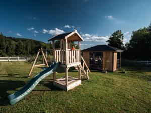 a wooden playground with a slide and a gazebo at SierPlejs Hill - domki przy szlaku w Górach Sowich in Sierpnica