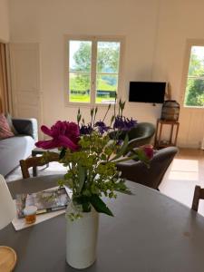 a vase of flowers on a table in a living room at Chateau de Salorges - Field gite I in Corancy