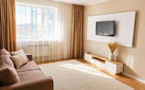 a living room with a couch and a tv at Ауельбекова 120 in Kokshetau