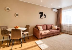a living room with a couch and a table at Ауельбекова 120 in Kokshetau +4 photos