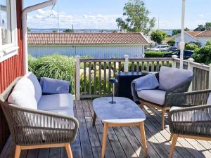 a patio with three chairs and a table on a deck at 4 star holiday home in onsala in Onsala