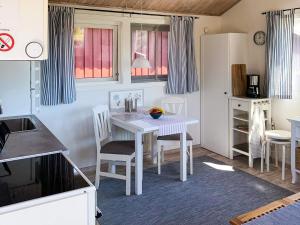 a kitchen with a white table and chairs in a room at 4 star holiday home in onsala in Onsala