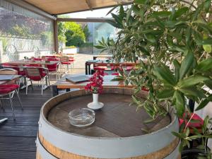 a patio with tables and chairs and flowers in a barrel at Haus der Gastlichkeit in Ratingen