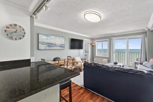 a living room with a couch and a table at Oceanfront Beach Condo, Pool, Gym, Fishing Surfing in Virginia Beach