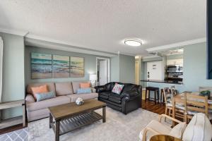a living room with a couch and a table at Oceanfront Beach Condo, Pool, Gym, Fishing Surfing in Virginia Beach