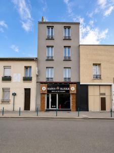 a building on the side of a street at Hotel de la gare in Pantin