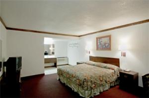a hotel room with a bed and a bathroom at Executive Inn Muldrow in Muldrow