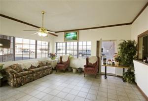 a living room with a couch and two chairs at Executive Inn Muldrow in Muldrow