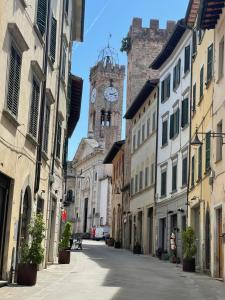 a city street with a clock tower in the background at Porta Toscana in Poggibonsi