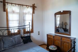 a bedroom with a bed with a mirror and a dresser at Pietra Mare Suites Villa in Palaión Eleftherochórion +26 photos