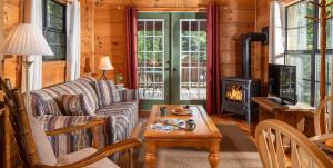 a living room with a couch and a stove at Engadine Inn and Cabins in Candler