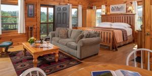 a living room with a couch and a bed at Engadine Inn and Cabins in Candler
