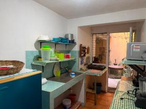 a kitchen with blue shelves in a room at Las Huellas del Caminante in Catemaco