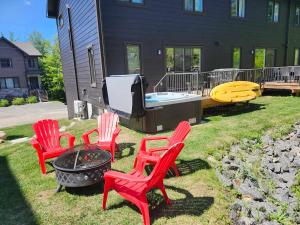 a group of red chairs and a fire pit at Chalet Essentiel 76 in Saint-Faustin