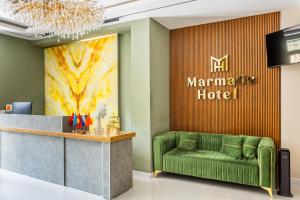 a lobby of a marmite hotel with a green couch at Marmaris Saray Hotel DOWNTOWN in Tashkent