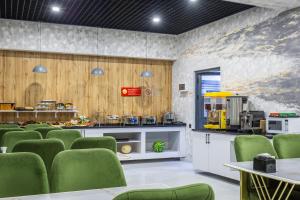 a waiting room with green chairs and a counter at Marmaris Saray Hotel DOWNTOWN in Tashkent