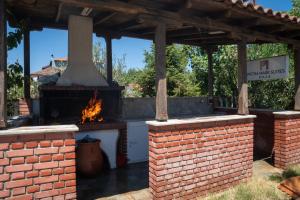 a brick patio with an outdoor oven in a yard at Pietra Mare Suites Villa in Palaión Eleftherochórion