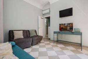 a living room with a couch and a tv on a wall at Cavour 96 Apartment in Florence